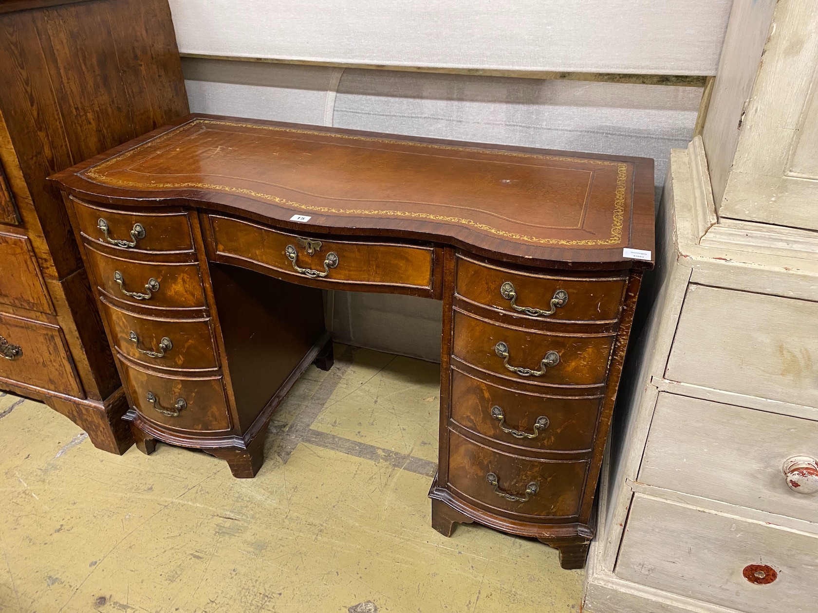 A reproduction mahogany leather topped kneehole writing table, width 114cm, depth 53cm, height 75cm